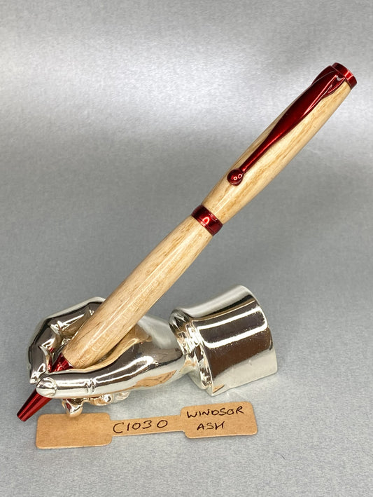 Ash wood pen with red plated fittings  standing on a chrome plated hand shape