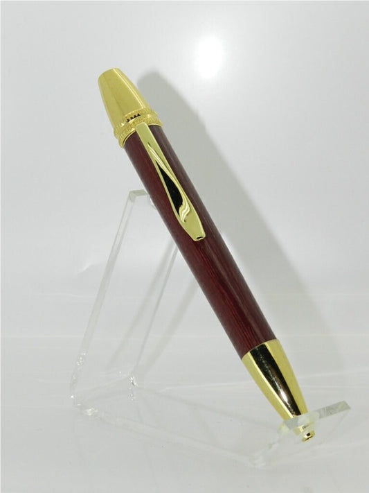 A Ball point Parker style pen in Pink Ivory wood, it's showing a nice deep purple colour it has gold plated fittings with a knurled  serrated type edge at the top to help identify the top and also help with the grip and twisting  action to propel and retract the nib. The nib end is also Gold plated and is thicker and more rounded in look.  The clip is quite long and broad to help keep it secure where ever you decide to put it.