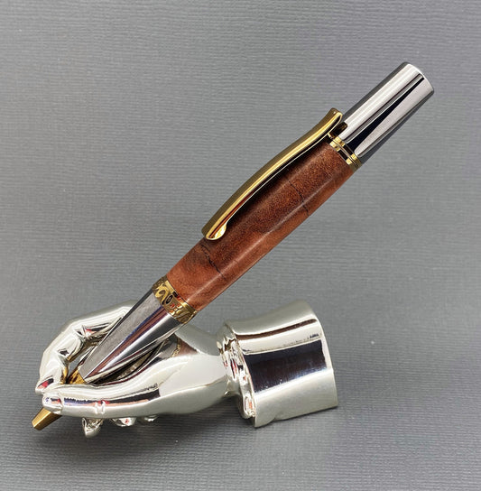 A right hand shaped metal base shown holding a handturned Amboyna Burr wood pen as you would hold it to write with.