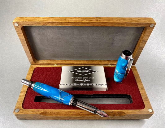 Open lidded box showing a Blue Acrylic Fountain pen the pen has chrome plated fittings
