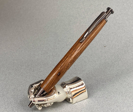 A right hand shaped metal base shown holding a handturned English 17th century church Oak wood pen as you would hold it to write with.