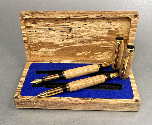 Spalted Beech wood hand crafted presentation box with its lid open showing two hand crafted and turned pens made from French Oak and has Gold Plated fittings