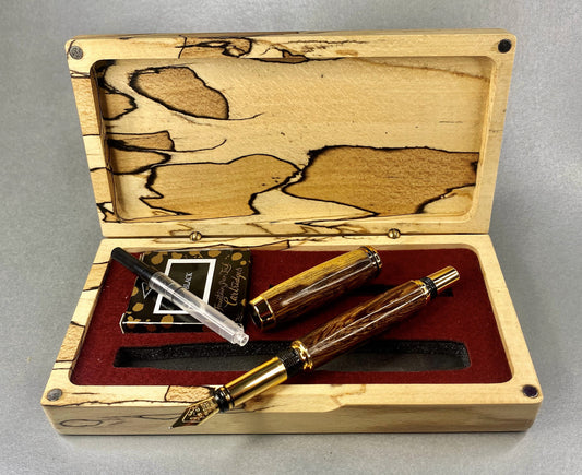 Spalted Beech wood hand crafted presentation box with its lid open showing one hand turned hand crafted pen made from Panga Panga Wood, It has Gold Plated fittings and black accents on the nib.